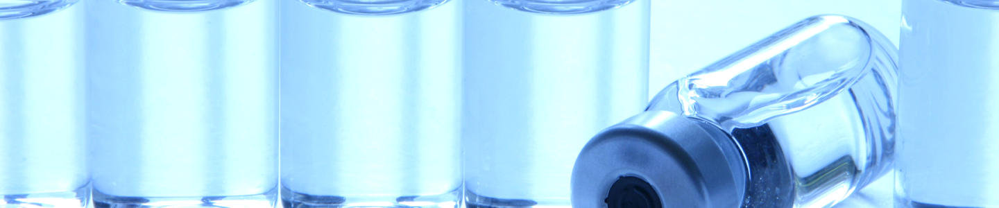 Clear vials sealed with silver caps, one vial lying on its side being punctured by syringe.