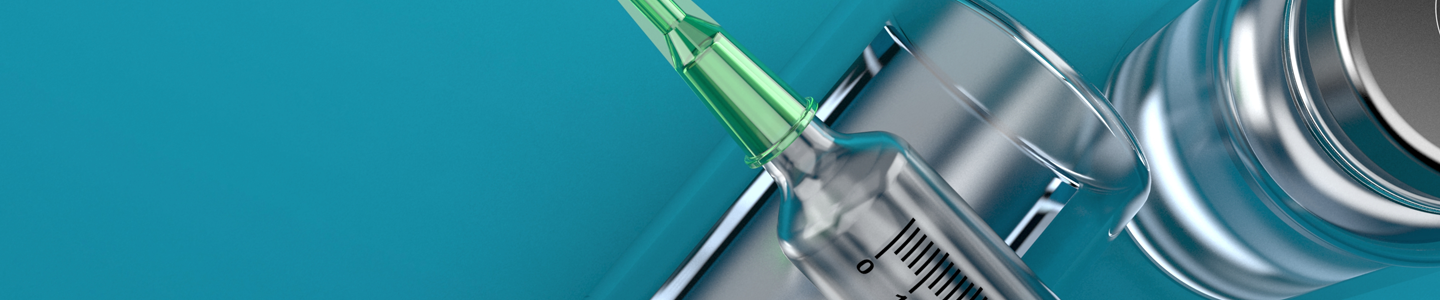 Close-up of syringe with needle resting on vial with metal cap.