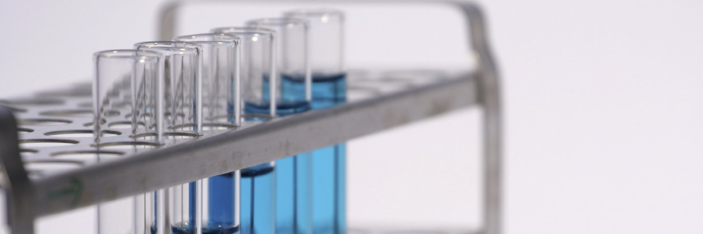 Close-up of rack of test tubes containing clear blue liquid.