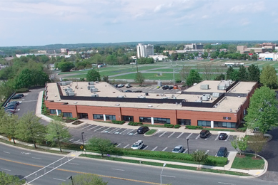 Aerial view of the ATCC biorepository building, parking lot, grass, and trees in Gaithersburg, Maryland.