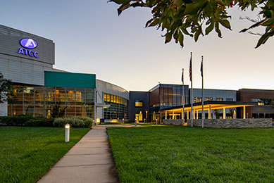 New ATCC building entrance at dusk with lights.