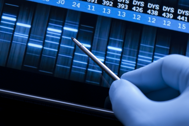 Gloved hand holding metal pointer over DNA sequence on digital display screen.