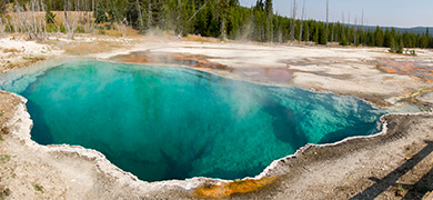 A steaming, bright-blue hot spring in Yellowstone National Park.