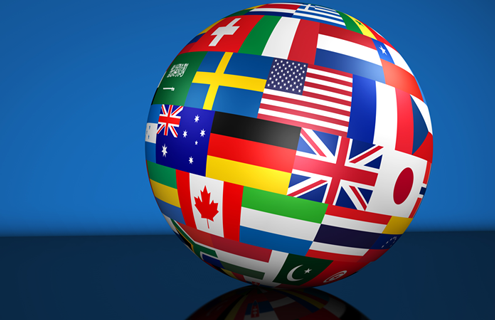 A globe made up of bright-colored flags from different countries.