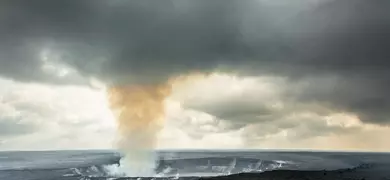 Gray fog and steam rising from the Halema'uma'u Crater within the Kilauea Caldera in Hawaii Volcanoes National Park.