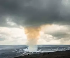 Gray fog and steam rising from the Halema'uma'u Crater within the K?lauea Caldera in Hawaii Volcanoes National Park.