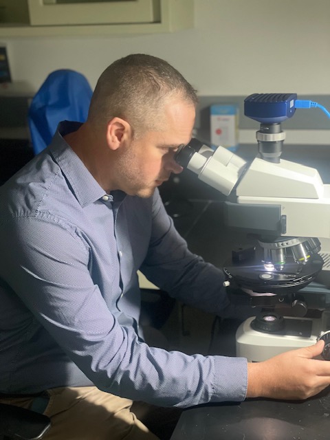 James Crill at microscope in lab