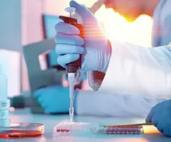 Scientist injecting liquid into a microtiter plate