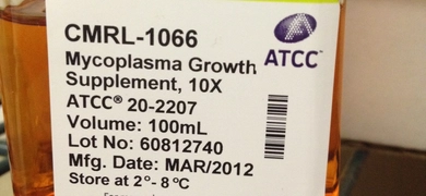 A clear glass bottle containing orange liquid labeled “CMRL-1066 Mycoplasma Growth Supplement, 10X ATCC® 20-2207.” The label includes volume (100mL), lot number (60812740), manufacturing date (MAR/2012), and storage instructions (2°–8°C). It states the product is for research use only and not for human, clinical, or diagnostic use. Contact information and a website link for ATCC in Manassas, VA are also present.