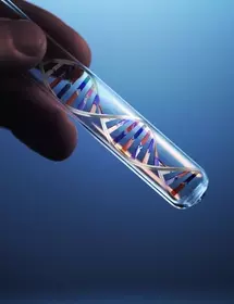 Fingers holding a test tube containing a silver, red, and blue DNA double helix.