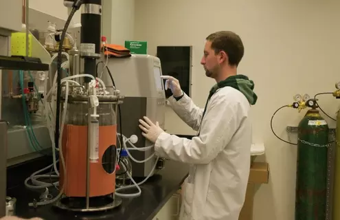 ATCC scientist standing at lab equipment.