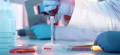 Scientist injecting liquid into a microtiter plate