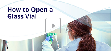 A person wearing protective eyewear and gloves handles a glass vial with green caps in a laboratory setting. The image includes the text "How to Open a Glass Vial" and a play button icon, indicating a video tutorial.